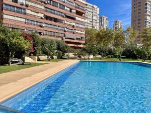 a large blue swimming pool in front of a building at Principado Wifi, Airco, Beach and Garden in Benidorm
