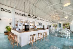 a large room with a bar and tables and chairs at Sempiak Seaside Resort in Selong Belanak