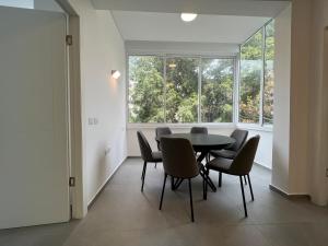 a dining room with a table and chairs and a window at Smolenskin 3 Bedrooms Apartment in Tel Aviv