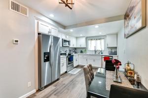 a kitchen with a stainless steel refrigerator and a table at San Diego Condo Pool Access, 8 Mi to Downtown in San Diego