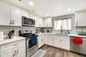 a kitchen with white cabinets and a stove top oven at San Diego Condo Pool Access, 8 Mi to Downtown in San Diego