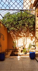 a courtyard with a table and trees in a building at maison d'hôtes Le petit jardin Marrakech in Marrakech