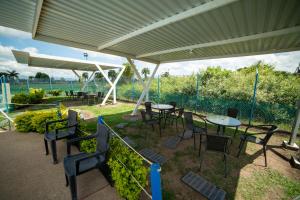 un groupe de tables et de chaises sous un parapluie dans l'établissement Parque del Cafe Apartamento! Piscinas, Parqueadero, WiFi, Netflix., à Montenegro