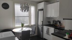 a white kitchen with a table and a window at Central Park Home in Turku