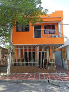 an orange house with a gate in front of it at Casa Eguis in Gaira
