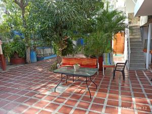 a patio with a table and chairs on a brick floor at Casa Eguis in Gaira