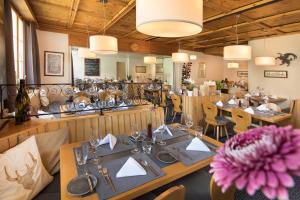 un restaurante con mesas y sillas de madera y una flor en Hotel Vincenz, en Brigels