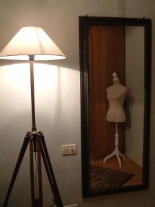 a mirror and a lamp and a mannequin in a room at La Casa della Peggiola - Le Case Antiche in Verucchio
