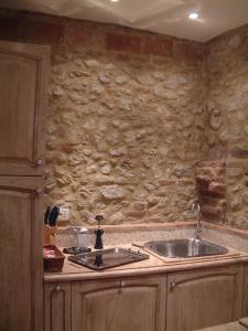 a kitchen with a sink and a stone wall at La Casa della Peggiola - Le Case Antiche in Verucchio