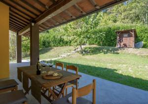 un patio con tavolo, sedie e cortile di B&B Naturista e Spa Mondoselvaggio a Lucca