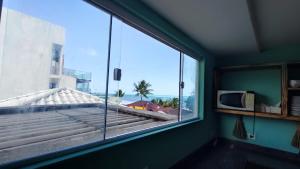 a room with a large window with a view of the ocean at Fabika Pousada in Maragogi