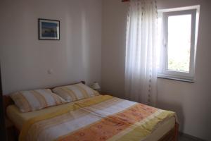 Habitación pequeña con cama y ventana en Mediterranean Oasis Apartments en Baška