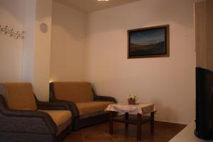 una sala de espera con 2 sillas y una mesa en Mediterranean Oasis Apartments en Baška