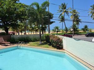uma piscina num resort com palmeiras e uma rua em LUXOR CABO BRANCO - JOIA RARA Beira Mar em João Pessoa