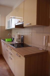 cocina con armarios blancos y encimera en Mediterranean Oasis Apartments en Baška