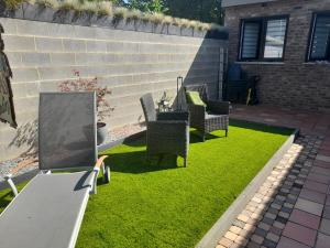 a backyard with chairs and a table and grass at Chez Francis in Verviers