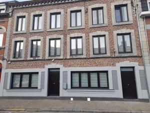 a large brick building with black doors and windows at Chez Francis in Verviers
