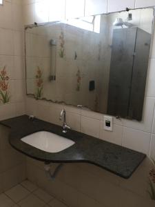 ein Bad mit einem Waschbecken und einem Spiegel in der Unterkunft Estações in Campinas