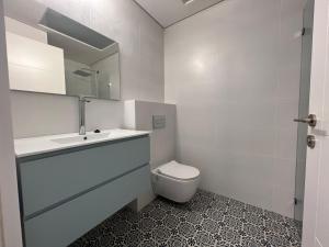 a bathroom with a toilet and a sink and a mirror at Smolenskin 3 Bedrooms Apartment in Tel Aviv