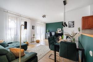 Prime Location Apartment في بودابست: غرفة معيشة مع أريكة خضراء وطاولة