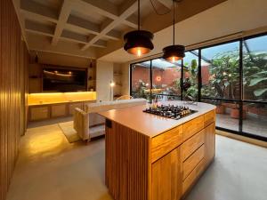 cocina con isla y ventana grande en Hojarasca by Wynwood House, en Medellín