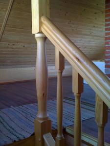 a set of wooden stairs in a house at Cabin with a sauna& pond+a hot Tub(additional fee) in Ķeņini