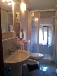 a bathroom with a sink and a toilet and a shower at Meublè Al Ponte in Grado