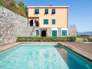 a house with a swimming pool in front of a building at Appartamento le isole M in Portovenere