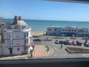 Blick auf ein Gebäude und einen Parkplatz mit Strand in der Unterkunft The Jubilee Hotel - with Spa and Restaurant and Entertainment in Weymouth