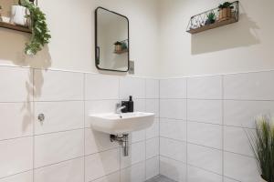 ein weißes Badezimmer mit einem Waschbecken und einem Spiegel in der Unterkunft 2 Bed New York Style Loft Apartment Free Parking in Bradford
