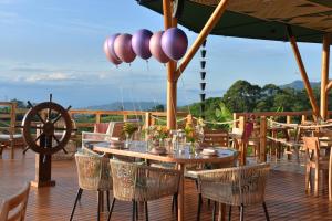 a wooden deck with a wooden table and chairs at LA PERLA FINCA HOTEl- Cabaña Esmeralda in Gigante