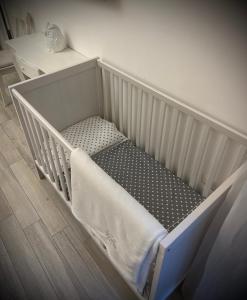 a white crib in a room with a table at Maison Mele Ischia in Ischia