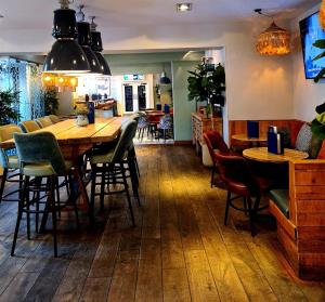 a restaurant with a large wooden table and chairs at The Townhouse Sutton in Sutton Coldfield