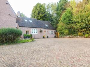 a house with a brick driveway in front of it at Farley Cottage I in Oakamoor