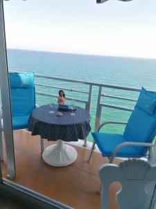 a woman sitting at a table on a cruise ship at apartamento junto al mar in Cullera