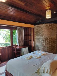 1 dormitorio con 1 cama grande con sábanas blancas en Pousada Casa Canto das Águas, en Icaraí