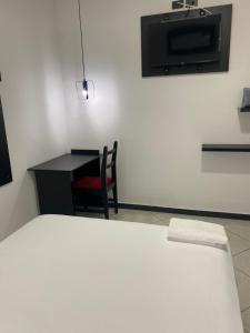 1 dormitorio con 1 cama, escritorio y TV en BRYSS HOTEL, en Santo Domingo de los Colorados