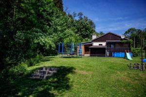 a yard with a playground with a building and a house at Chalupa Sedmidvory in Vernířovice