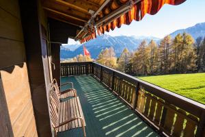 a bench on the balcony of a house with a view at Haus Chalet Beverin in Cazis