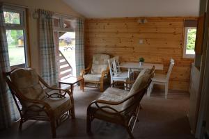 a living room with a table and chairs in a cabin at Reuben's Highland Retreat - Speyside in Carrbridge