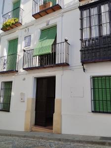 biały budynek z balkonami i drzwiami w obiekcie LA CASA DEL VIENTO ATQ w mieście Antequera