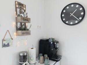 Villa Colonia Vir في فير: غرفة مع آلة صنع القهوة وساعة على الحائط