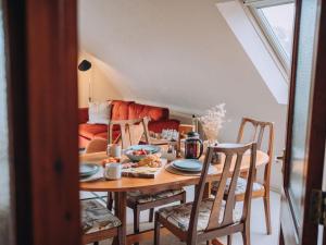 a dining room with a table and chairs and a couch at The Loft - A Stylish Holiday Property in Weymouth with Sea View and Parking in Weymouth