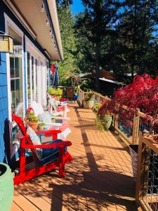 eine Terrasse mit roten Stühlen und Tischen auf einem Haus in der Unterkunft Ocean Mist Getaway(OMG) in Eastsound