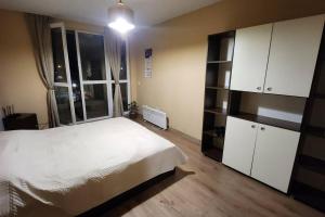 a bedroom with a white bed and a large window at Budget overnight- Struma highway in Pernik