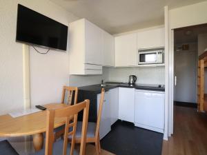 a small kitchen with a wooden table and a small kitchen with white cabinets at Studio Tignes, 1 pièce, 4 personnes - FR-1-502-535 in Tignes