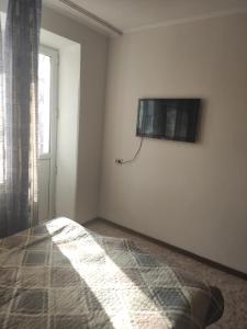 a bedroom with a bed and a tv on the wall at 1 комнатные апартаменты в районе Атакента in Almaty