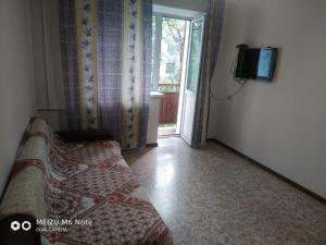 Habitación con cama, TV y ventana. en 1 комнатные апартаменты в районе Атакента, en Almaty