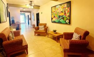 una sala de estar con sillas y una pintura en la pared en El Roble Hotel, en Bacalar