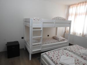 two bunk beds in a room with two beds at Skigyimes Guesthouse in Lunca de Sus